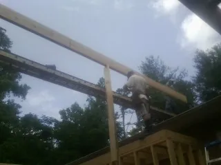 Carpenter setting a ridge beam over a new addition frame — Ice Dam Removal by Roofing Brothers in Quinebaug