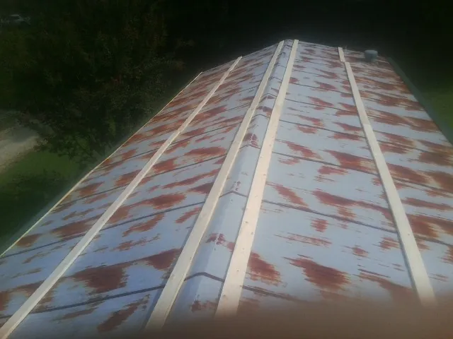 Rusted metal roof panels with new wood purlins before replacement — Storm Damage Roof Repair in Quinebaug by Roofing Brothers
