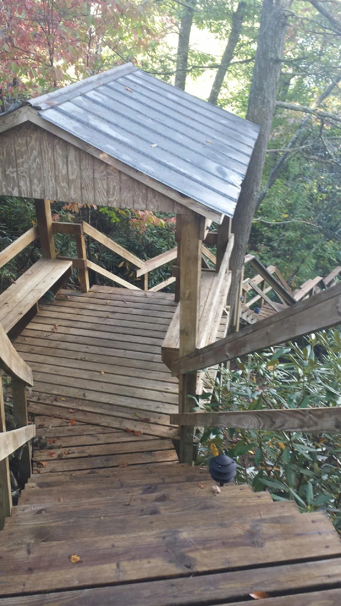 Metal roofed shelter over wooden steps on a wooded walkway — Skylight Repair & Installation work by our crew in Quinebaug